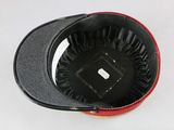 a close up of a black and red hat on a white surface