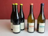 quatre bouteilles de vin sont alignées sur une table