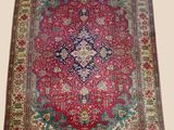a red and blue rug with a medallion design on it