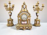trois horloges anciennes posées les unes à côté des autres sur une table