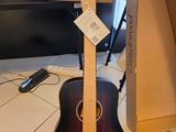 une guitare posée par terre devant une boîte