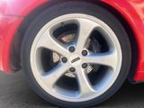 a close up of a red car ' s tire on the street