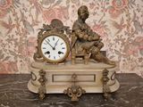 a statue of a man sitting on a table with a clock in front of him