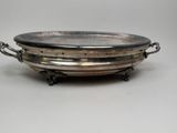 an antique silver plate with handles and handles on a stand