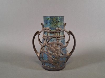 a blue vase with a metal handle on a table