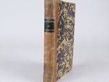 an old book sitting on top of a white surface