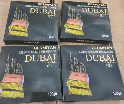 quatre boîtes de chocolats de Dubaï posées sur une boîte en carton posée sur une table