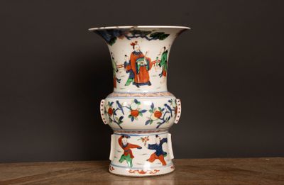 un vase blanc orné d'un motif coloré, posé sur une table