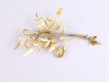 gold flower brooch with leaves and pearls on a white background