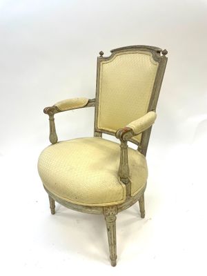 an old chair with a beige upholstered seat and a wooden frame