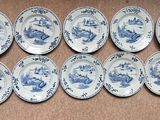 six plates with blue and white designs on them on a brown surface