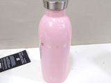 a pink water bottle sitting on a white table