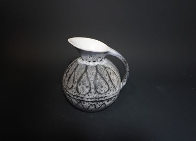 a black and white vase with a spoon in it
