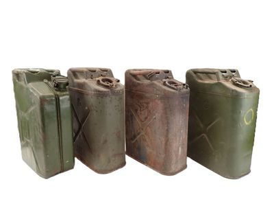 three old metal cans are lined up on a white surface