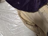 un chapeau violet posé sur une pile d'oreillers blancs