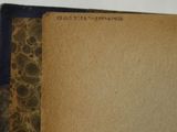 an old book is open on a white surface with a brown cover