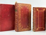 six livres rouges alignés sur une surface blanche