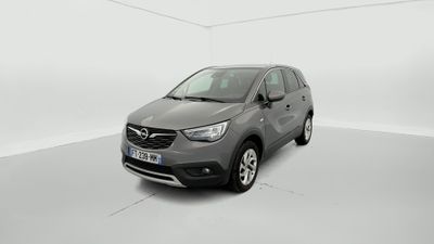 Une voiture grise est garée dans une pièce blanche au sol blanc.