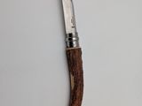 a knife that is laying on top of a piece of wood