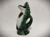 a green and white vase with a fish on it