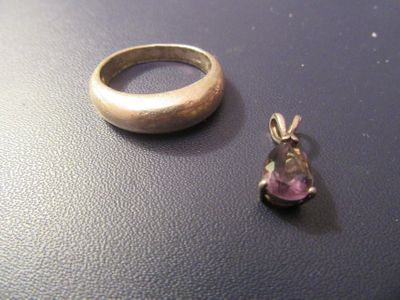une bague en argent et une pierre rose posées sur une table