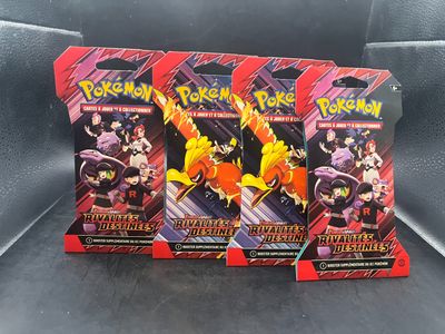 trois paquets de cartes à collectionner Pokémon posés sur une surface noire