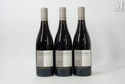 trois bouteilles de vin rouge sont posées sur une surface blanche