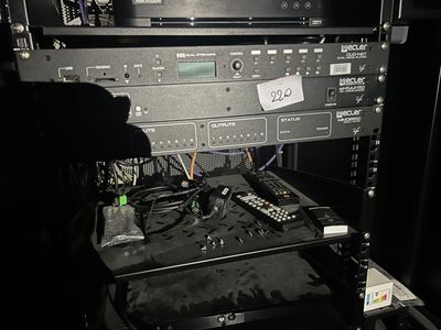 une photo d'un rack d'équipements électroniques dans une pièce sombre