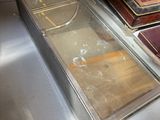 une casserole en métal posée sur une table, à côté d'une pile de livres