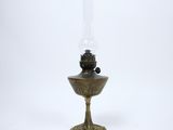 an antique oil lamp with a glass base on a white background