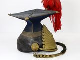 an old helmet with a red feather on top of it