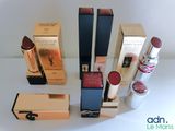 several different types of lipsticks and boxes on a white surface