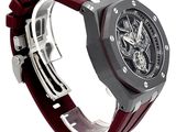 an image of a watch on a white surface with a red strap