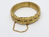 un gros plan d'un bracelet en or entouré d'une chaîne