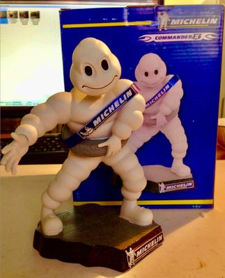 une figurine représentant un homme tenant une brosse à dents devant un tube de dentifrice