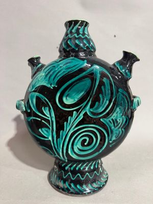 a blue vase with a black and green design on it