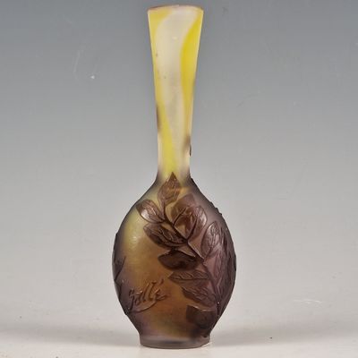 a glass vase with a design of leaves and flowers on it