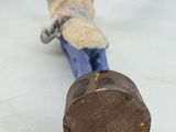 a toy of a person holding a hammer on a white surface