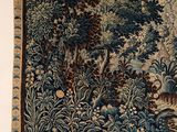a tapestry hanging on the wall with a vase in front of it