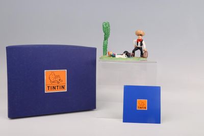 une petite figurine représentant un homme assis devant une cabine bleue