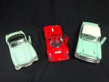 three toy cars are sitting side by side on a black surface