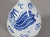 a blue and white vase with a fish design on it