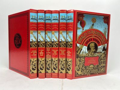 trois livres dans une boîte rouge posée sur une surface blanche