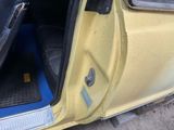 a yellow car with its door open on the side of the road