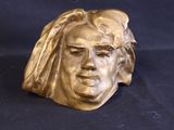 brass sculpture of a woman ' s face with a veil on her head
