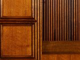 a wooden paneled wall with a bench in front of it