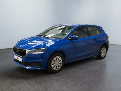 Une voiture bleue est garée dans une pièce aux murs blancs.