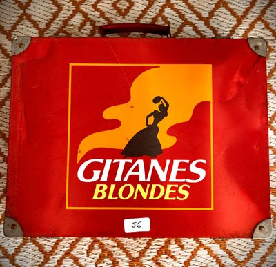 une valise rouge sur laquelle est représentée une femme
