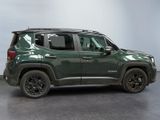 the green jeep is parked in a room with a white wall