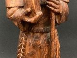 statue of an old man with a beard and a hat holding a sheep